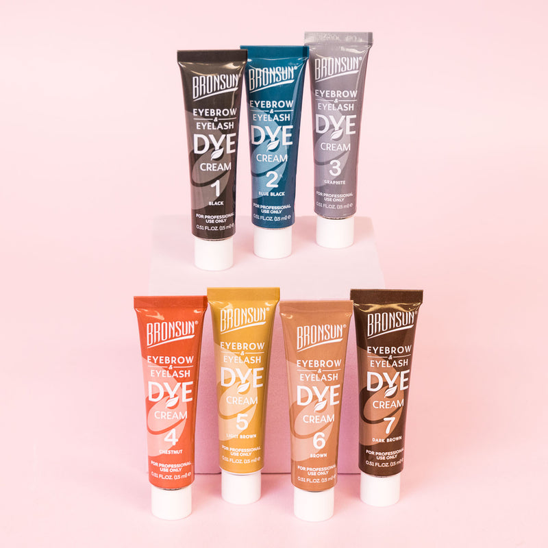 Tubes of brow and lash cream dye in various colours on pink background displayed