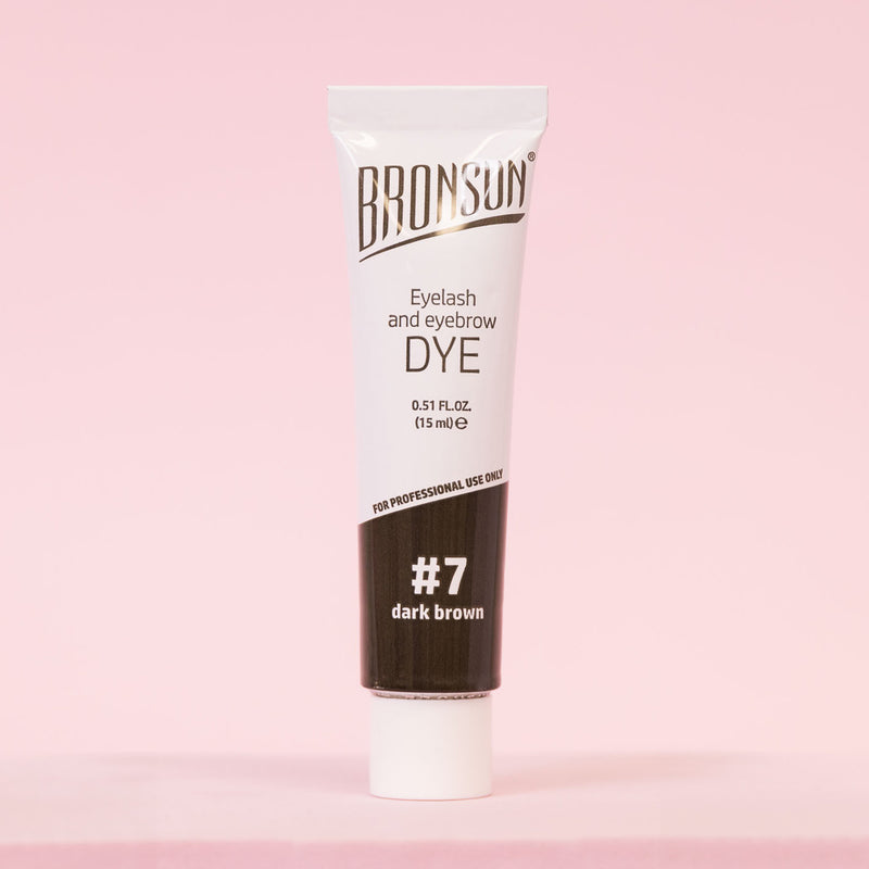 Eyelash and eyebrow dye dark brown product displayed on pink background 