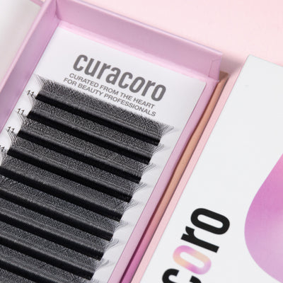 Close-up of Curacoro 5D Clover Lashes  tray with black lash extensions in a pink box.