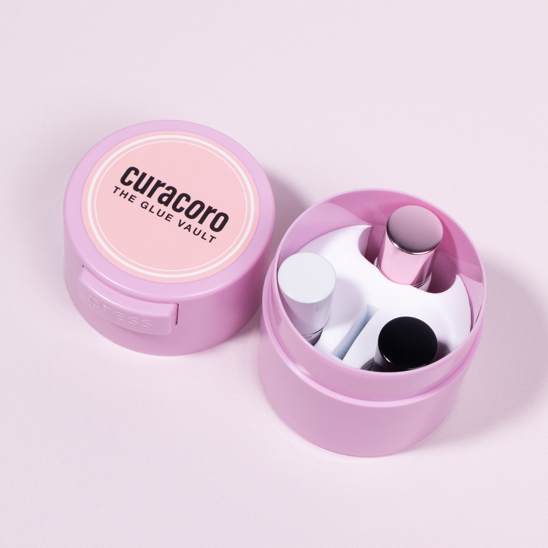 Pink Curacoro Glue Vault adhesive storage container with an open lid showing the inner compartment.