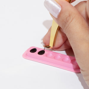 Individual Disposable Glue Holder with Glue and Tweezer Holding a Lash