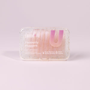 Curacoro Heavenly Huggers lash lift shields in a glittery transparent case containing 8 pairs of thick teardrop-shaped shields.