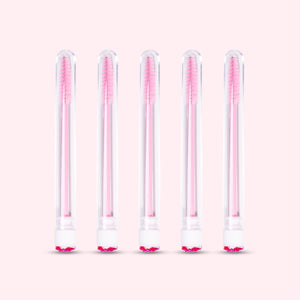 Five pcs Mascara Brushes with Tubes over a light pink background. 