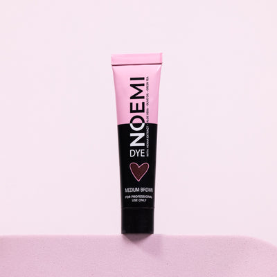 Noemi Hybrid Brow & Lash Dye - Medium Brown Bottle Over Pink Background