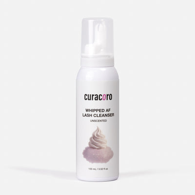 White bottle of curacoro whipped AF lash cleanser on a white background