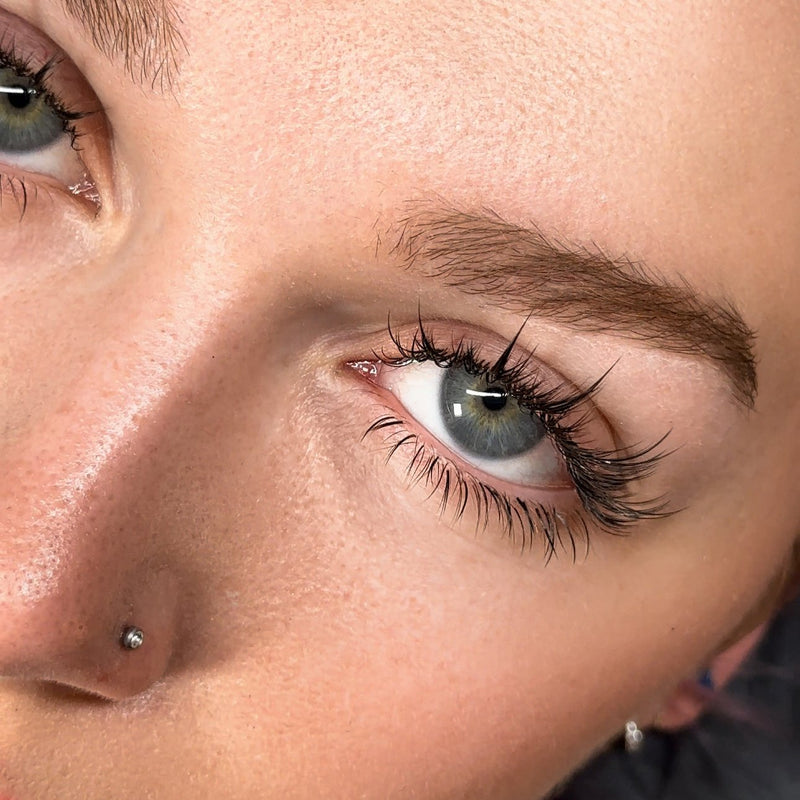 Close-up of a blue eye with voluminous anime-style lashes.