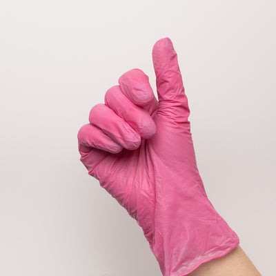 Pink disposable glove on model's hand.