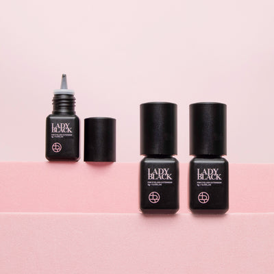 Three Lady black glue bottles for lash extensions, one with the lid open