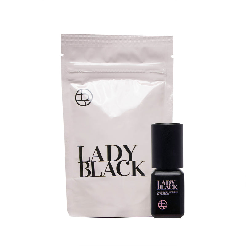 Lady Black glue for eyelash extensions with bottle and packaging displayed in the background.