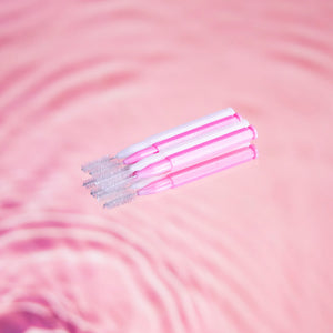 Brow Lamination Comb Brush pack in front of pink background.