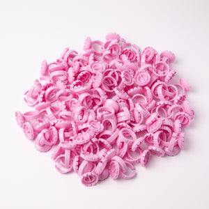 Pink Glue Rings (100 pcs) over a white background. 