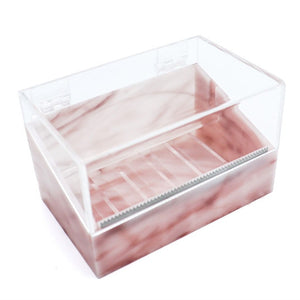 Pink marble acrylic tape dispenser with a clear hinged lid, built-in serrated cutter, and multiple slots for organizing tape rolls.